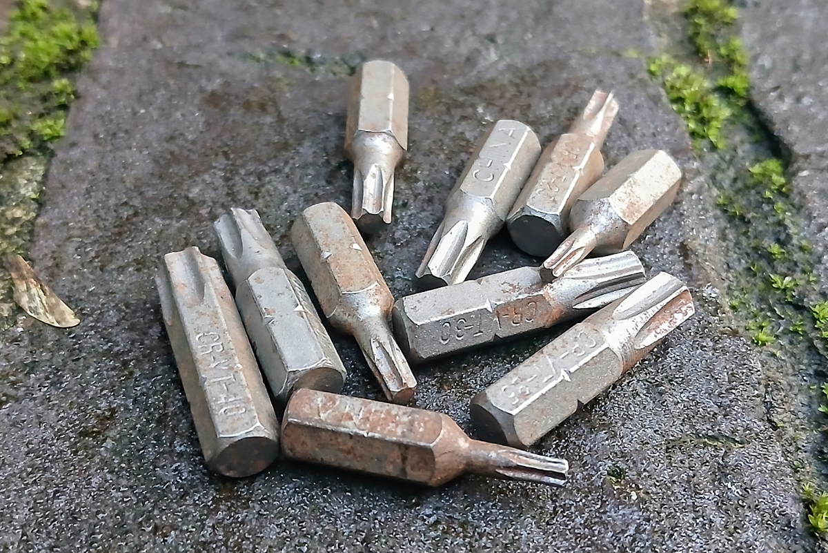 A close-up of a number of rust Torx screwdriver bit heads