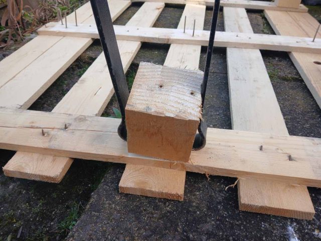 Using the curved ends of flat pry bars to remove pallet blocks.