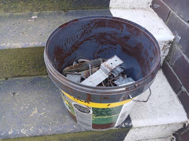 Keeping all the removed nails in a paint bucket for recycling.