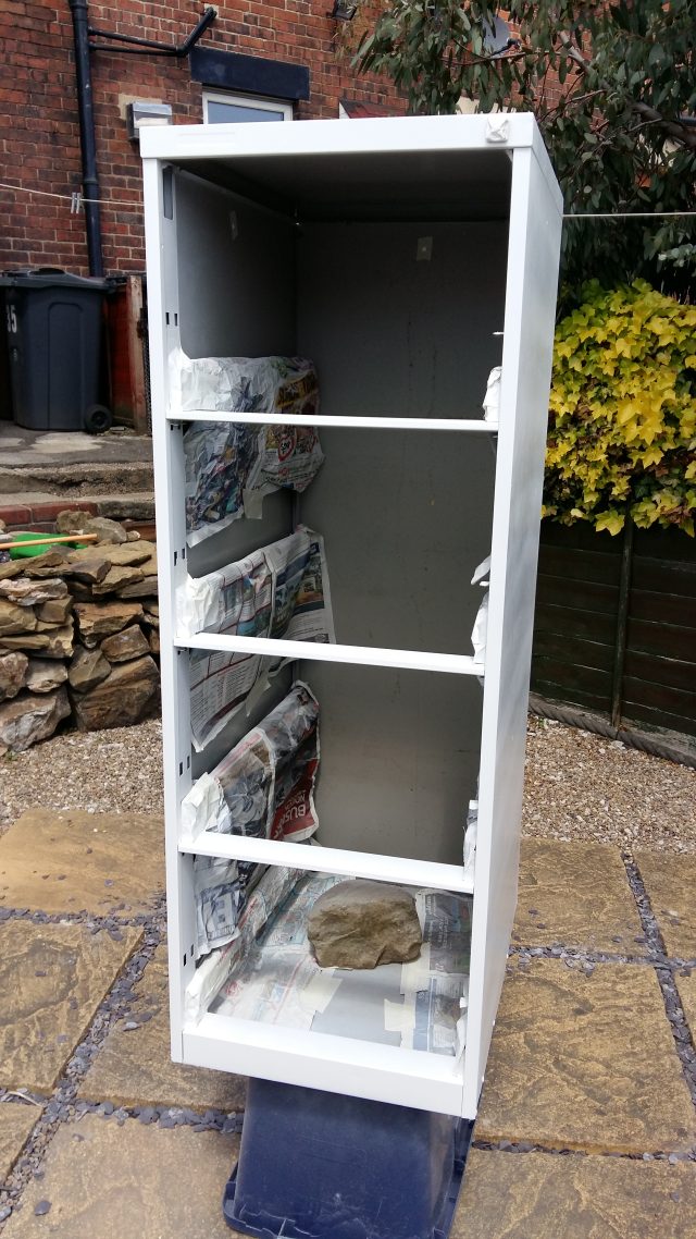 Image of a filing cabinet frame, spray painted white.