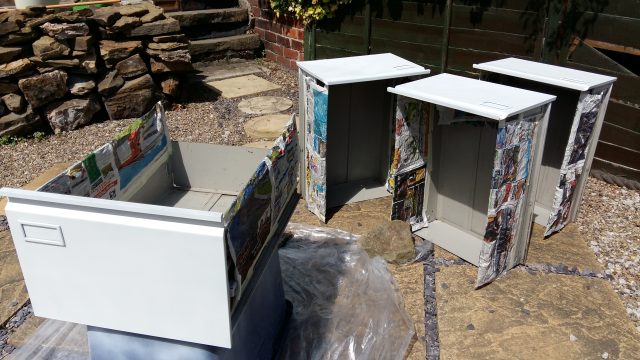 An image of four filing cabinet drawers, covered in a light grey primer.