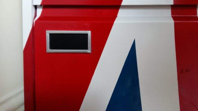 A close-up image of the card holder on a filing cabinet drawer. The drawer is painted red, white and blue.