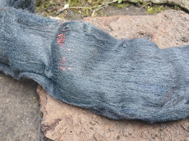 Image shows steel wool burning on a square of rusted metal.