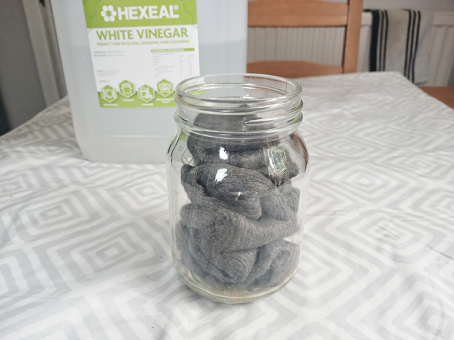 Image shows a lidless glass jar filled with steel wool.