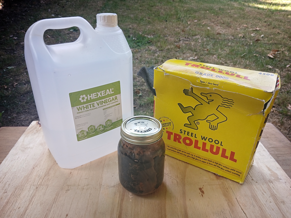 Image shows a 5 litre bottle of white vinegar next to a box of 0000 grade steel wool, with a jar containing Oak Burnish in the middle.