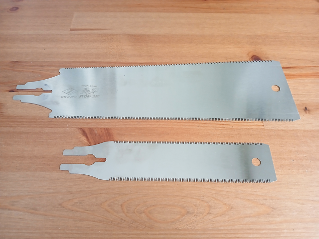 Image shows two Ryoba-style ZETSAW replacement blades laid one above the other. Shown on a wooden background.